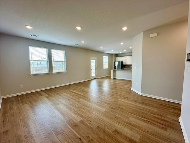 149 Gullivers Dr, Elgin, TX 78621 - unfurnished living room featuring light wood finished floors and recessed lighting