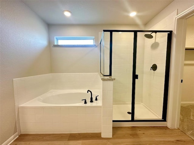149 Gullivers Dr, Elgin, TX 78621 - full bathroom featuring a bath, wood finished floors, and a stall shower