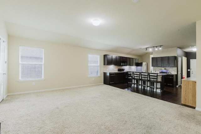 184 Voss St, Kyle, TX 78640 - kitchen with dark colored carpet, refrigerator, tasteful backsplash, open floor plan, and light countertops