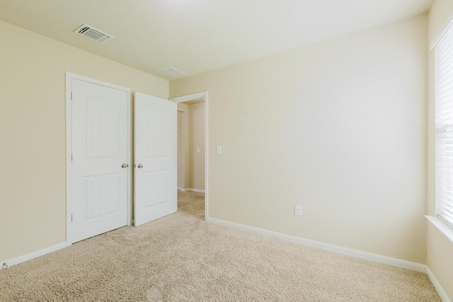 184 Voss St, Kyle, TX 78640 - unfurnished bedroom with carpet, multiple windows, and a closet