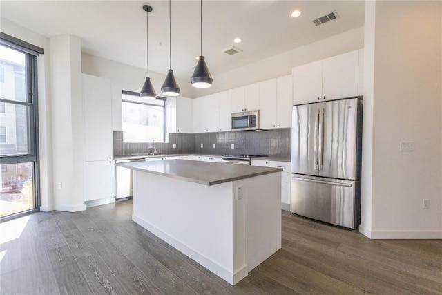 800 Embassy Dr Unit 137, Austin, TX 78702 - kitchen featuring stainless steel appliances, a kitchen island, dark wood finished floors, tasteful backsplash, and recessed lighting