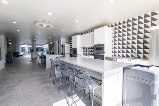800 Embassy Dr Unit 137, Austin, TX 78702 - kitchen featuring stainless steel appliances, light countertops, recessed lighting, white cabinetry, and finished concrete flooring