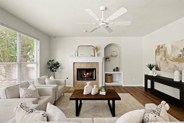 3416 Oxsheer Dr, Austin, TX 78732 - living room with wood finished floors, a tiled fireplace, arched walkways, and ceiling fan