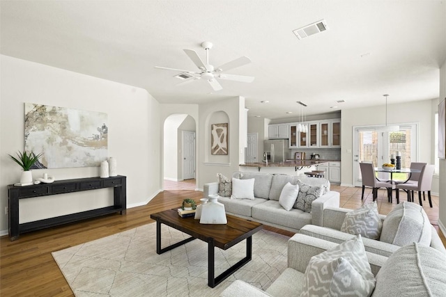3416 Oxsheer Dr, Austin, TX 78732 - living room featuring arched walkways, ceiling fan, and light wood-style flooring