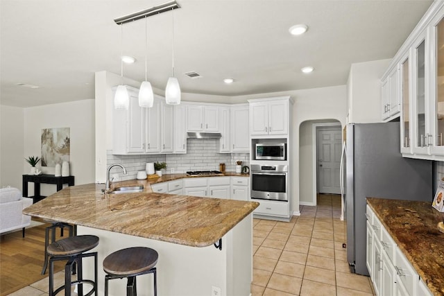 3416 Oxsheer Dr, Austin, TX 78732 - kitchen featuring stainless steel appliances, a peninsula, under cabinet range hood, white cabinets, and recessed lighting