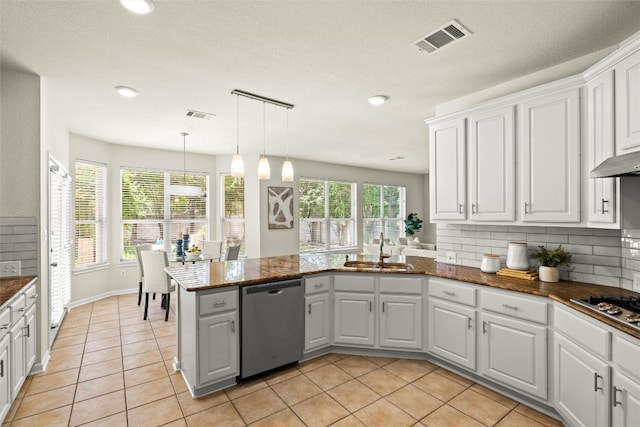 3416 Oxsheer Dr, Austin, TX 78732 - kitchen featuring appliances with stainless steel finishes, a peninsula, white cabinets, light tile patterned floors, and hanging light fixtures