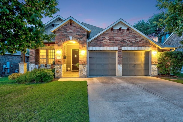232 Mandana St, Leander, TX 78641 - view of front of property with stone siding, driveway, a garage, and a lawn