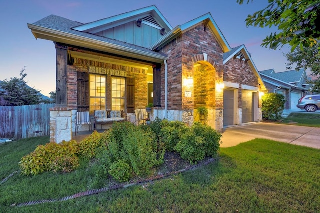 232 Mandana St, Leander, TX 78641 - view of front of house featuring board and batten siding, a garage, stone siding, driveway, and brick siding