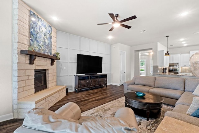 1329 Siena Sunset Rd, Leander, TX 78641 - living area with dark wood-style floors, a ceiling fan, a stone fireplace, and recessed lighting