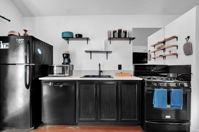1914 E 8th St, Austin, TX 78702 - kitchen with black appliances, open shelves, dark cabinetry, wood finished floors, and light countertops