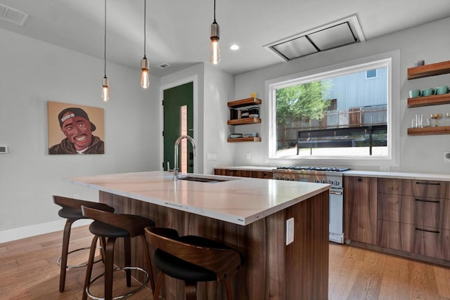1914 E 8th St, Austin, TX 78702 - kitchen featuring open shelves, high end stove, modern cabinets, light wood-type flooring, and a breakfast bar