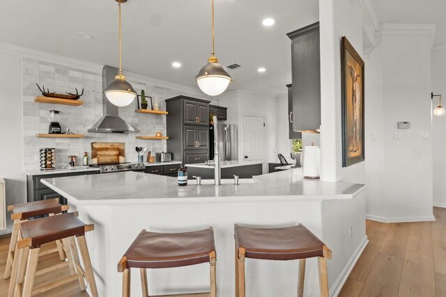 18113 Travis Dr, Lago Vista, TX 78645 - kitchen with open shelves, wall chimney exhaust hood, tasteful backsplash, a peninsula, and light wood-type flooring