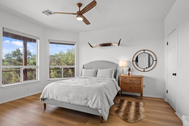 18113 Travis Dr, Lago Vista, TX 78645 - bedroom with multiple windows, wood finished floors, and ceiling fan
