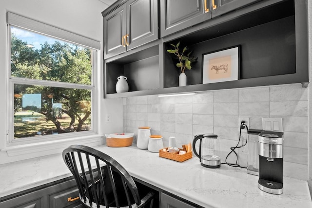 18113 Travis Dr, Lago Vista, TX 78645 - kitchen view of gray cabinetry, tasteful backsplash, open shelves, and a desk