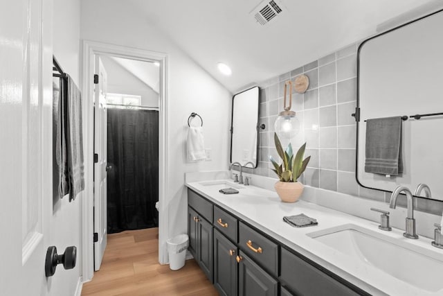 18113 Travis Dr, Lago Vista, TX 78645 - bathroom with double vanity, vaulted ceiling, wood finished floors, and a shower with curtain