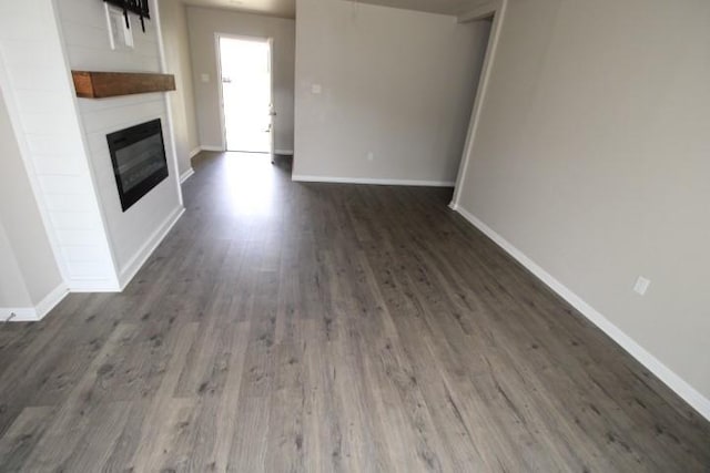 1109 W Lincoln Ave, Copperas Cove, TX 76522 - unfurnished living room with a glass covered fireplace and dark wood-style floors