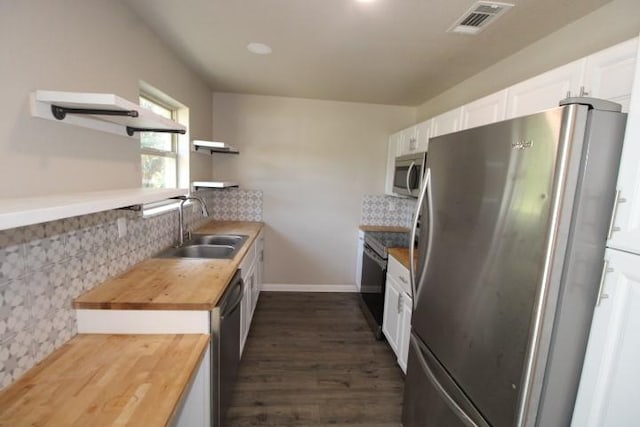 1109 W Lincoln Ave, Copperas Cove, TX 76522 - kitchen with appliances with stainless steel finishes, butcher block counters, open shelves, white cabinetry, and dark wood-style flooring