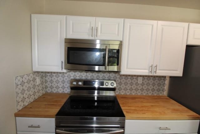 1109 W Lincoln Ave, Copperas Cove, TX 76522 - kitchen with appliances with stainless steel finishes, butcher block counters, decorative backsplash, and white cabinetry