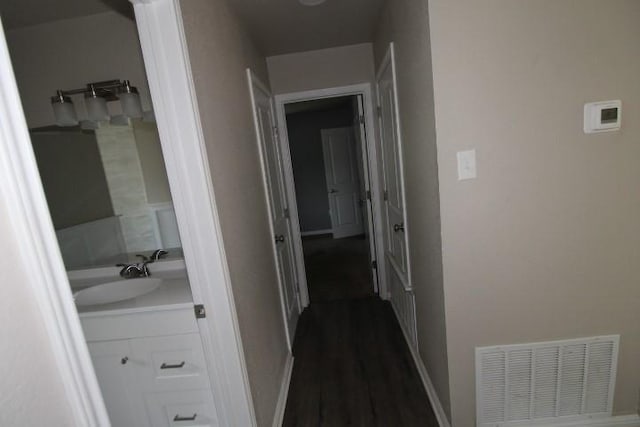 1109 W Lincoln Ave, Copperas Cove, TX 76522 - corridor featuring a sink and dark wood-style flooring