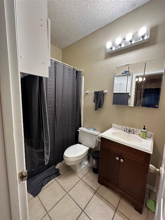 2414 Longview St Unit 301, Austin, TX 78705 - full bath featuring a textured ceiling, vanity, tile patterned floors, a textured wall, and a shower with curtain