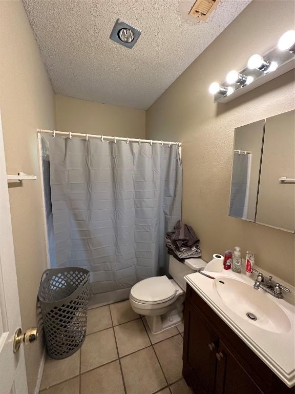 2414 Longview St Unit 301, Austin, TX 78705 - full bath featuring a textured ceiling, vanity, tile patterned flooring, and curtained shower