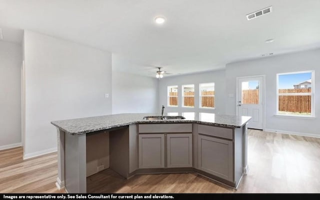 290 Yosemite Dr, Kyle, TX 78640 - kitchen featuring light wood-style flooring, ceiling fan, light stone counters, gray cabinets, and recessed lighting
