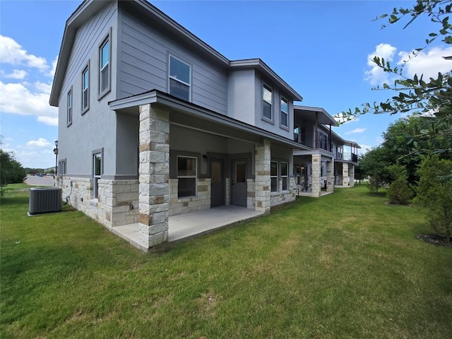 2105 Tiger Trl Unit 703, Round Rock, TX 78664 - back of property featuring stone siding, a yard, stucco siding, and a patio