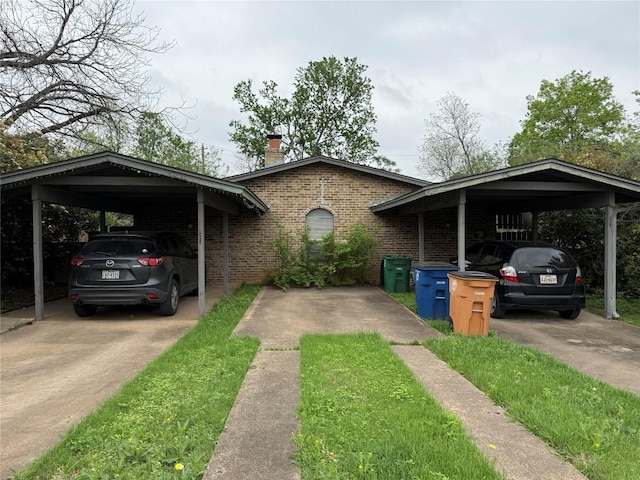 4907 Hawk Cv, Austin, TX 78745 - view of front of house featuring brick siding, a chimney, a detached carport, and driveway