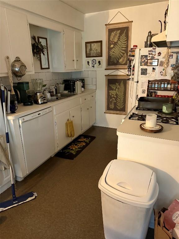 4907 Hawk Cv, Austin, TX 78745 - kitchen with white appliances, light countertops, white cabinets, and backsplash