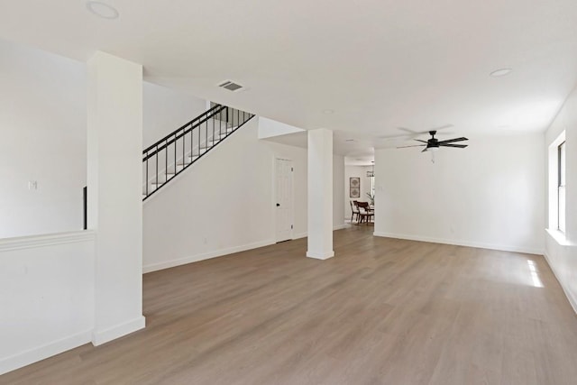 13265 Kerrville Folkway Dr, Austin, TX 78729 - unfurnished living room featuring light wood finished floors, ceiling fan, and stairway