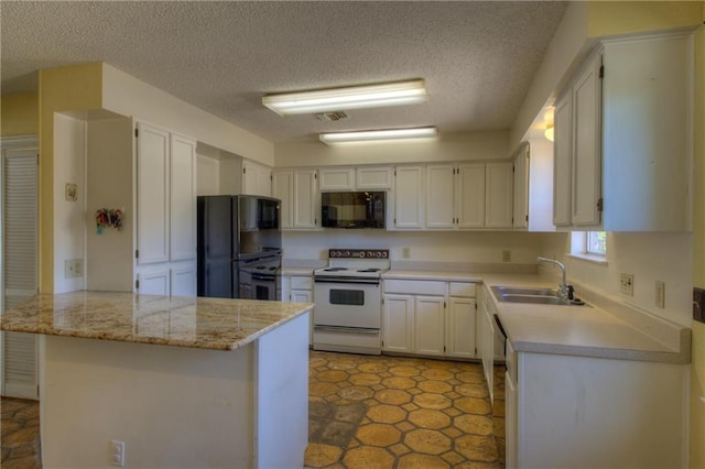1811 Lone Oak Dr, Leander, TX 78641 - kitchen with black appliances, a peninsula, a textured ceiling, light countertops, and white cabinets