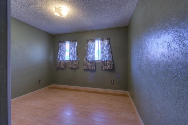 1811 Lone Oak Dr, Leander, TX 78641 - unfurnished room with wood finished floors, a textured ceiling, and a textured wall