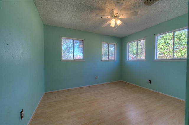 1811 Lone Oak Dr, Leander, TX 78641 - unfurnished room featuring a textured ceiling, light wood finished floors, and ceiling fan