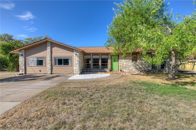 1811 Lone Oak Dr, Leander, TX 78641 - back of property with stone siding, a lawn, and concrete driveway