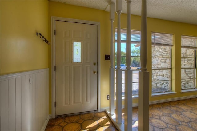 1811 Lone Oak Dr, Leander, TX 78641 - foyer featuring a textured ceiling and a wainscoted wall