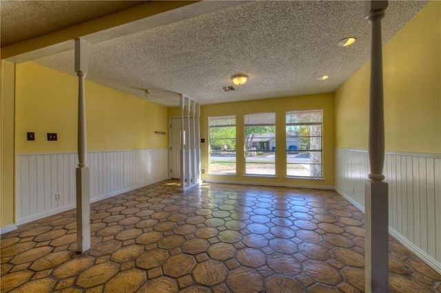 1811 Lone Oak Dr, Leander, TX 78641 - unfurnished room with wainscoting and a textured ceiling