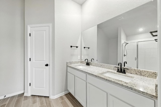 149 Hackberry Ln, Bastrop, TX 78602 - full bathroom featuring a shower stall, double vanity, and wood finish floors