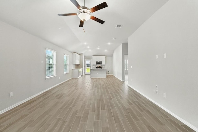 149 Hackberry Ln, Bastrop, TX 78602 - unfurnished living room with a ceiling fan, light wood-style floors, and high vaulted ceiling