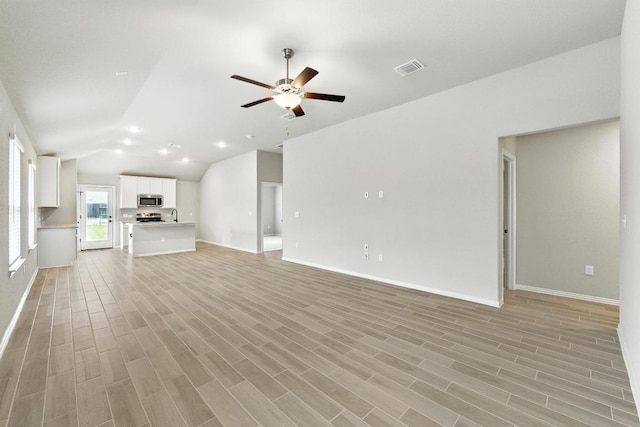 149 Hackberry Ln, Bastrop, TX 78602 - unfurnished living room with lofted ceiling, a ceiling fan, light wood finished floors, and recessed lighting