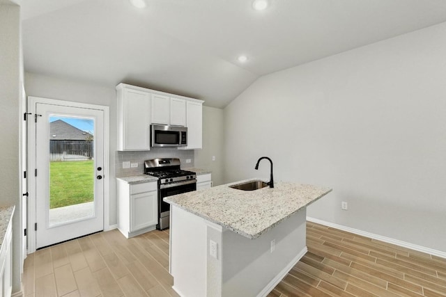 149 Hackberry Ln, Bastrop, TX 78602 - kitchen with stainless steel appliances, light wood-style floors, decorative backsplash, white cabinets, and recessed lighting