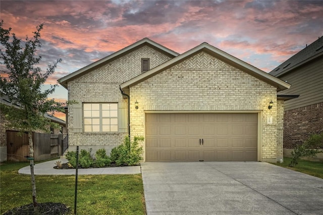 149 Hackberry Ln, Bastrop, TX 78602 - view of front of home with brick siding, driveway, an attached garage, and a yard