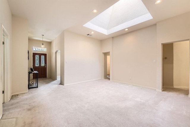 1108 Red Ranch Cir, Cedar Park, TX 78613 - unfurnished living room featuring a skylight, arched walkways, recessed lighting, light colored carpet, and a high ceiling