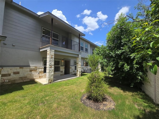 2105 Tiger Trl Unit 702, Round Rock, TX 78664 - back of property featuring a balcony, a patio, stone siding, and stucco siding