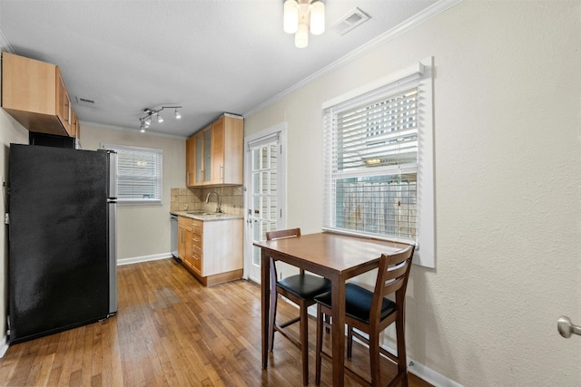 1110 W 22nd St Unit 1, Austin, TX 78705 - kitchen with stainless steel appliances, crown molding, decorative backsplash, wood finished floors, and light brown cabinets