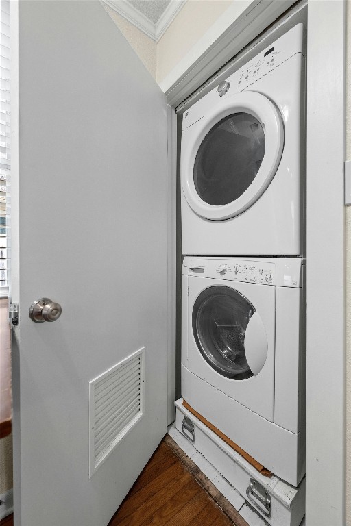 1110 W 22nd St Unit 1, Austin, TX 78705 - washroom with stacked washer and clothes dryer, crown molding, and dark wood finished floors