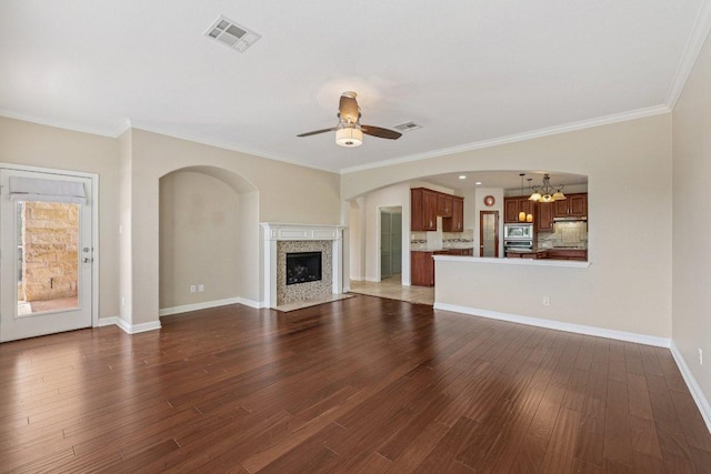 11421 Dona Villa Dr, Austin, TX 78726 - unfurnished living room featuring dark wood-style floors, a ceiling fan, a chandelier, a fireplace, and crown molding