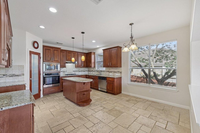 11421 Dona Villa Dr, Austin, TX 78726 - kitchen with stainless steel appliances, tasteful backsplash, recessed lighting, a kitchen island, and light stone countertops