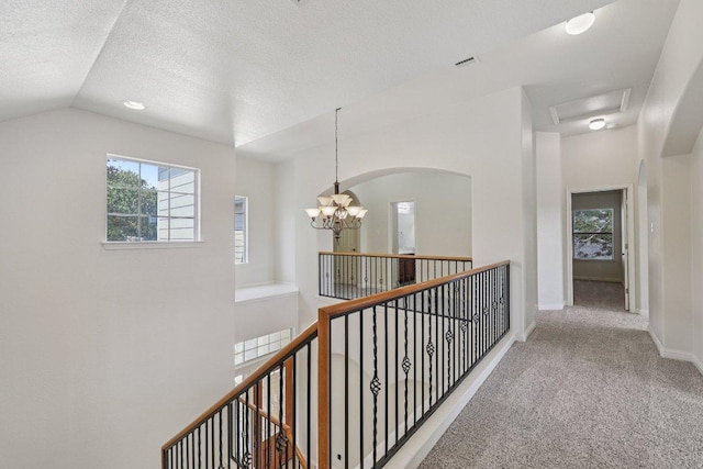 11421 Dona Villa Dr, Austin, TX 78726 - corridor featuring an upstairs landing, carpet floors, a chandelier, arched walkways, and a textured ceiling