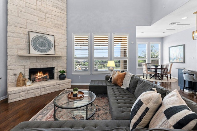 1702 Ambling Trl, Cedar Park, TX 78613 - living area featuring hardwood / wood-style flooring, a towering ceiling, and a stone fireplace