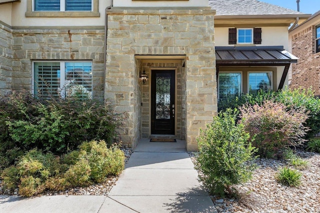 1702 Ambling Trl, Cedar Park, TX 78613 - view of exterior entry featuring stone siding, a standing seam roof, a metal roof, and stucco siding